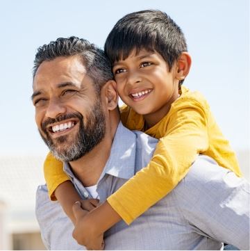 Man carrying child on his back.
