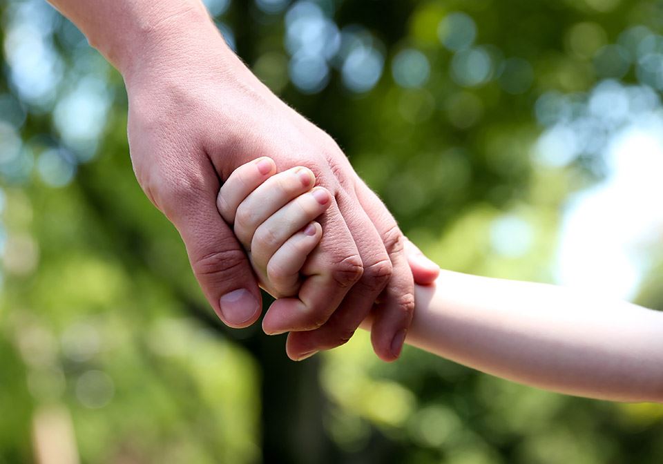 child and parent holding hands